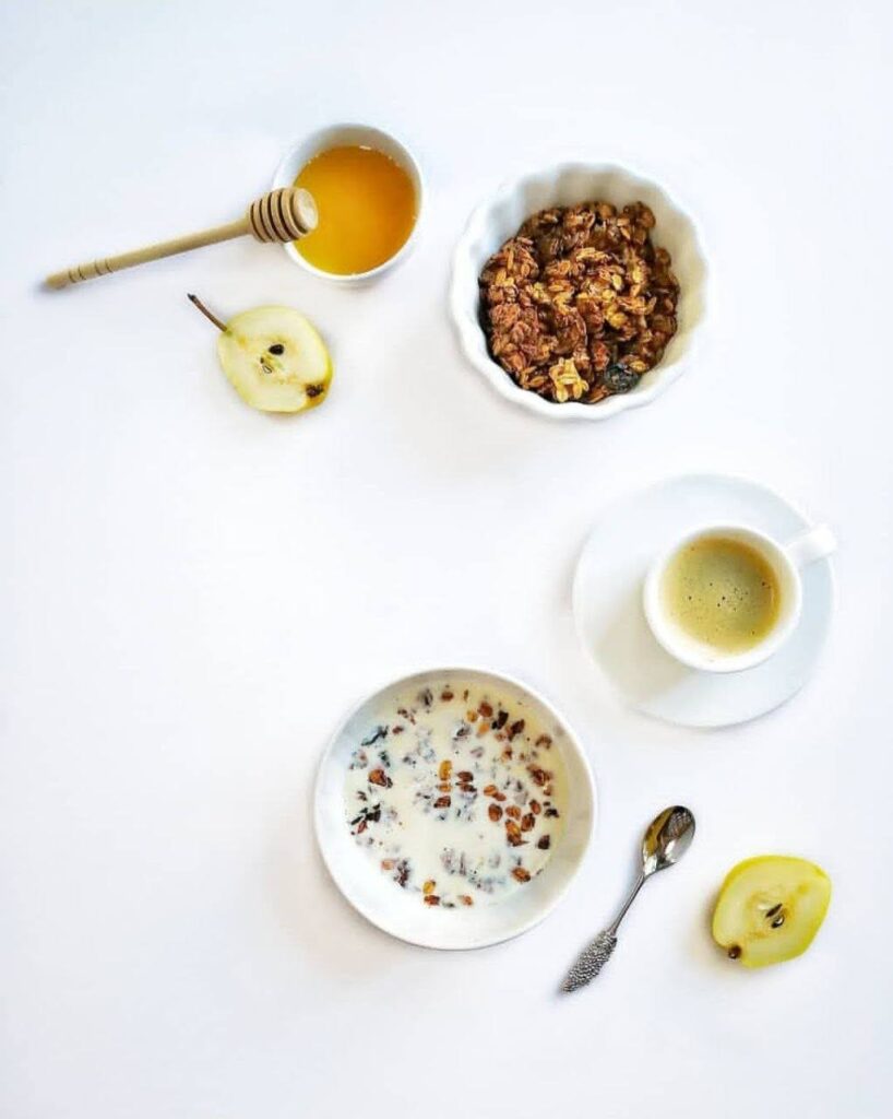 Гранола может быть вкуснее и полезнее, если приготовить ее дома самостоятельно. Фото завтрака: кофе, фрукт и гранола с молоком